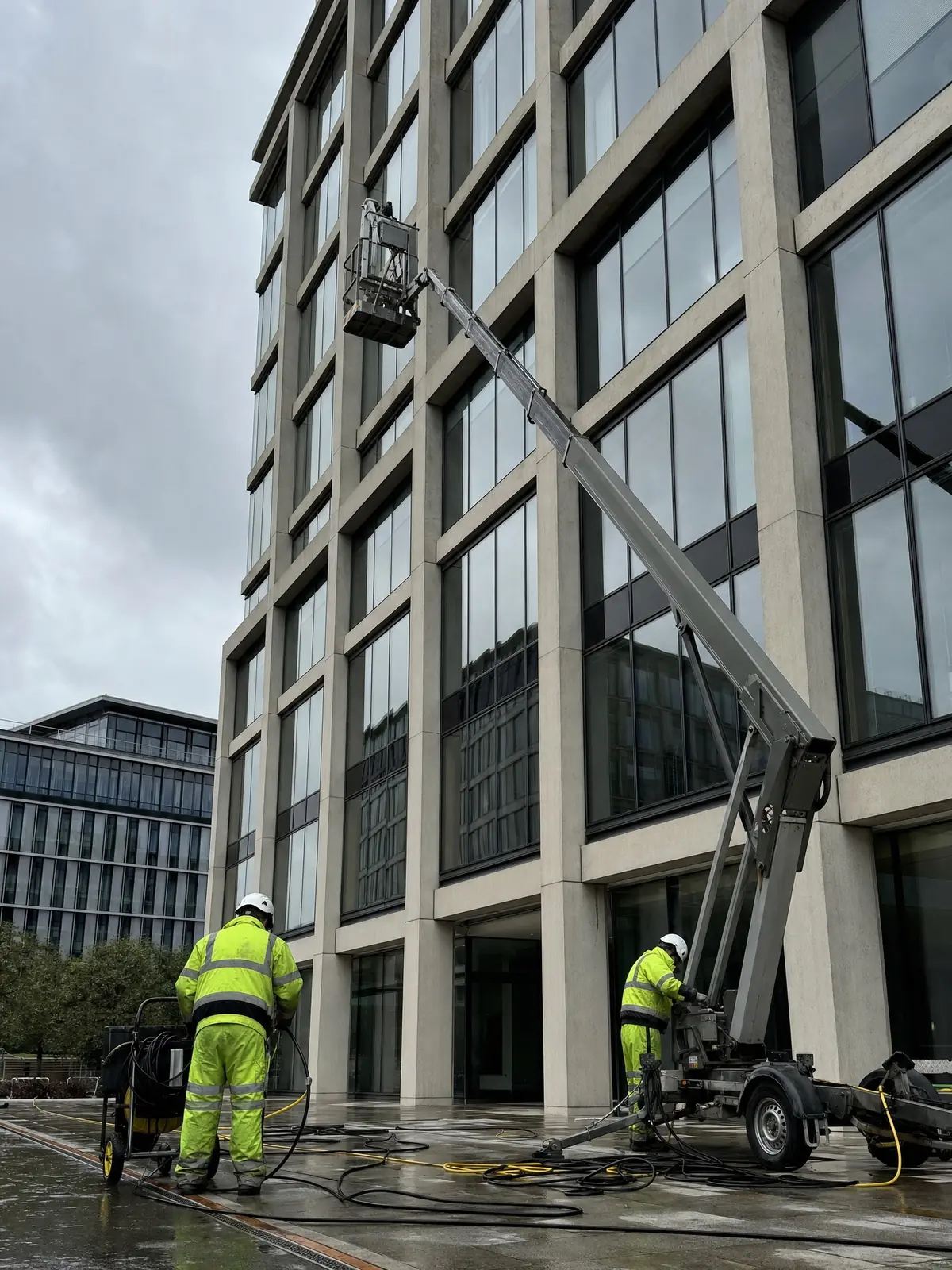 Operatives setting up access equipment at a large commercial building