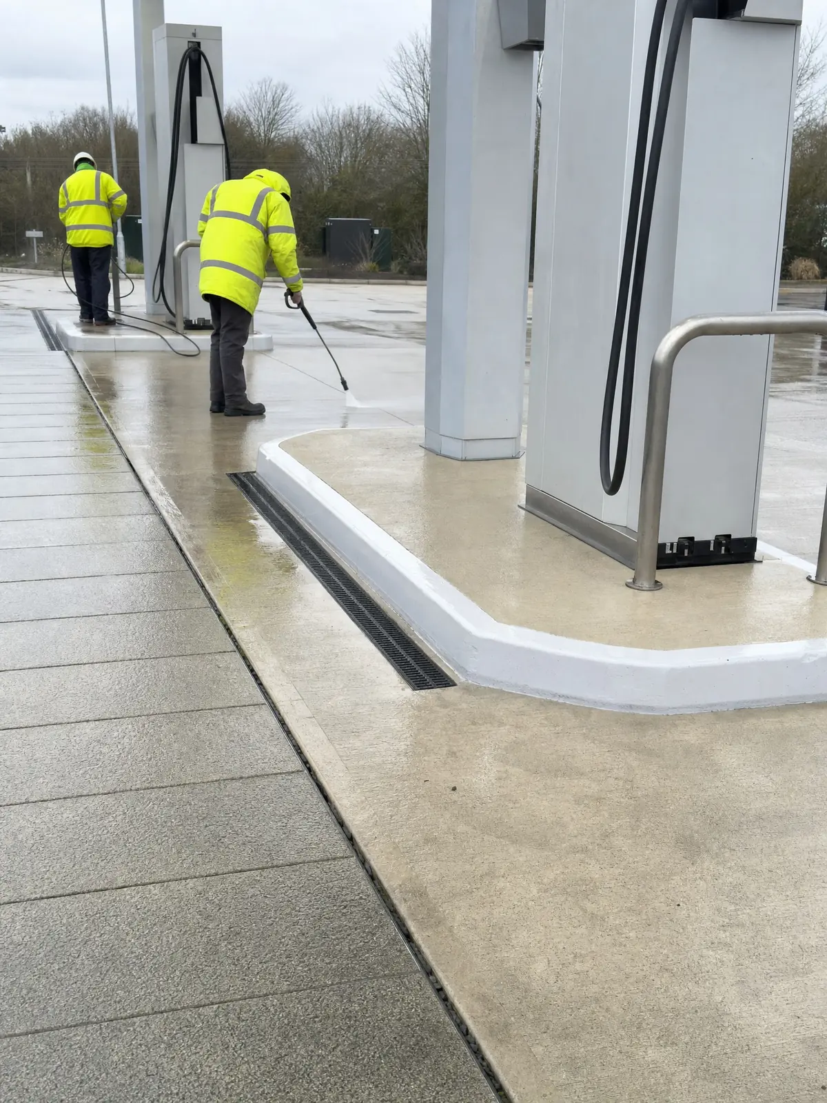 Concrete forecourt paving, kerbs and drainage channels around blank pump islands