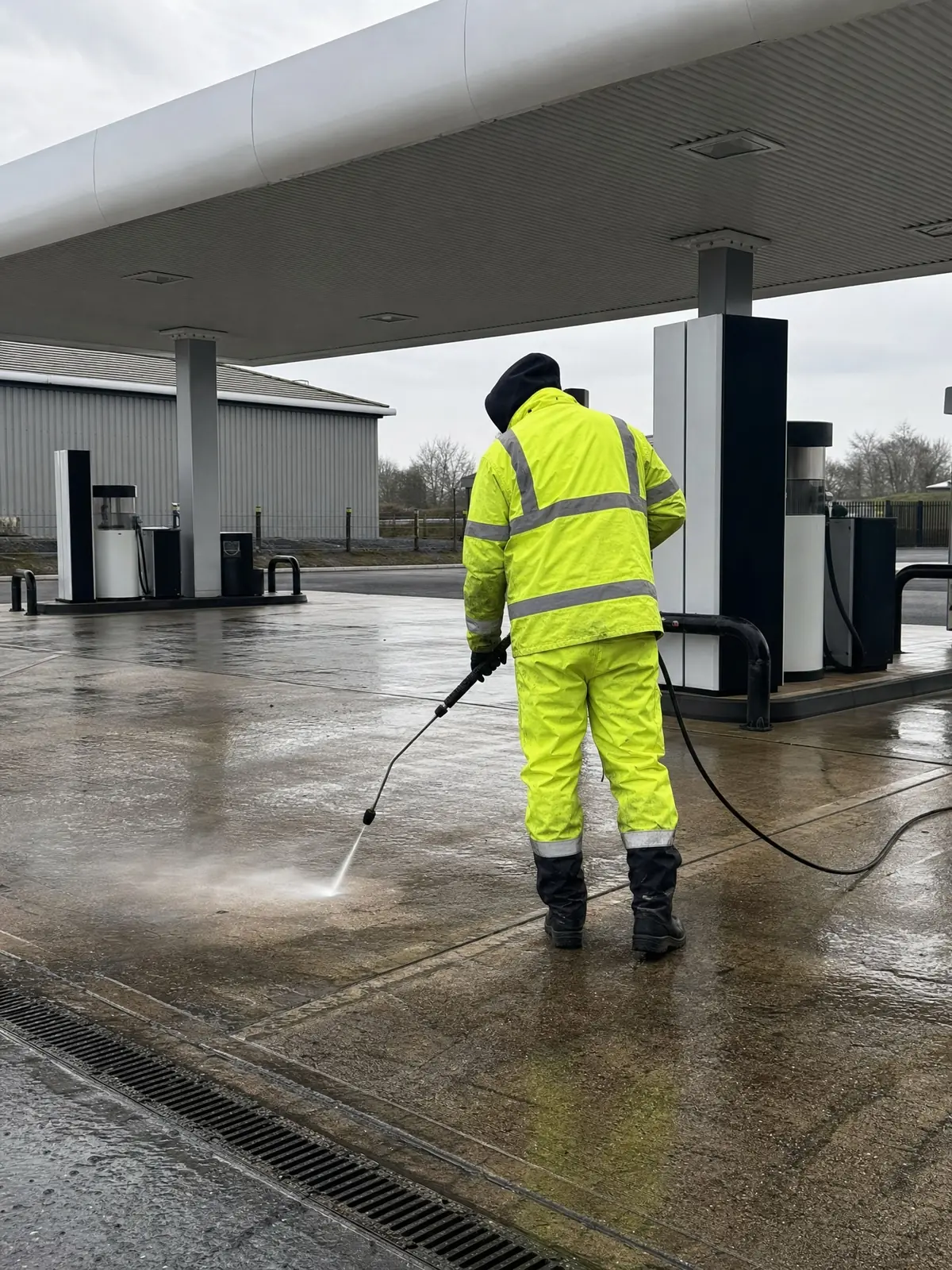 Cleaning a fuel-station forecourt around the pumps