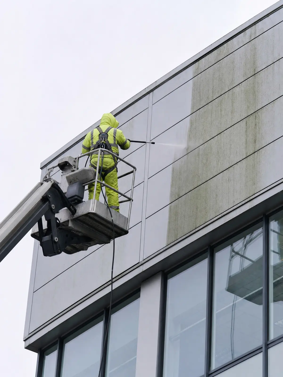 ICC operative carrying out high-level cladding cleaning from an access platform