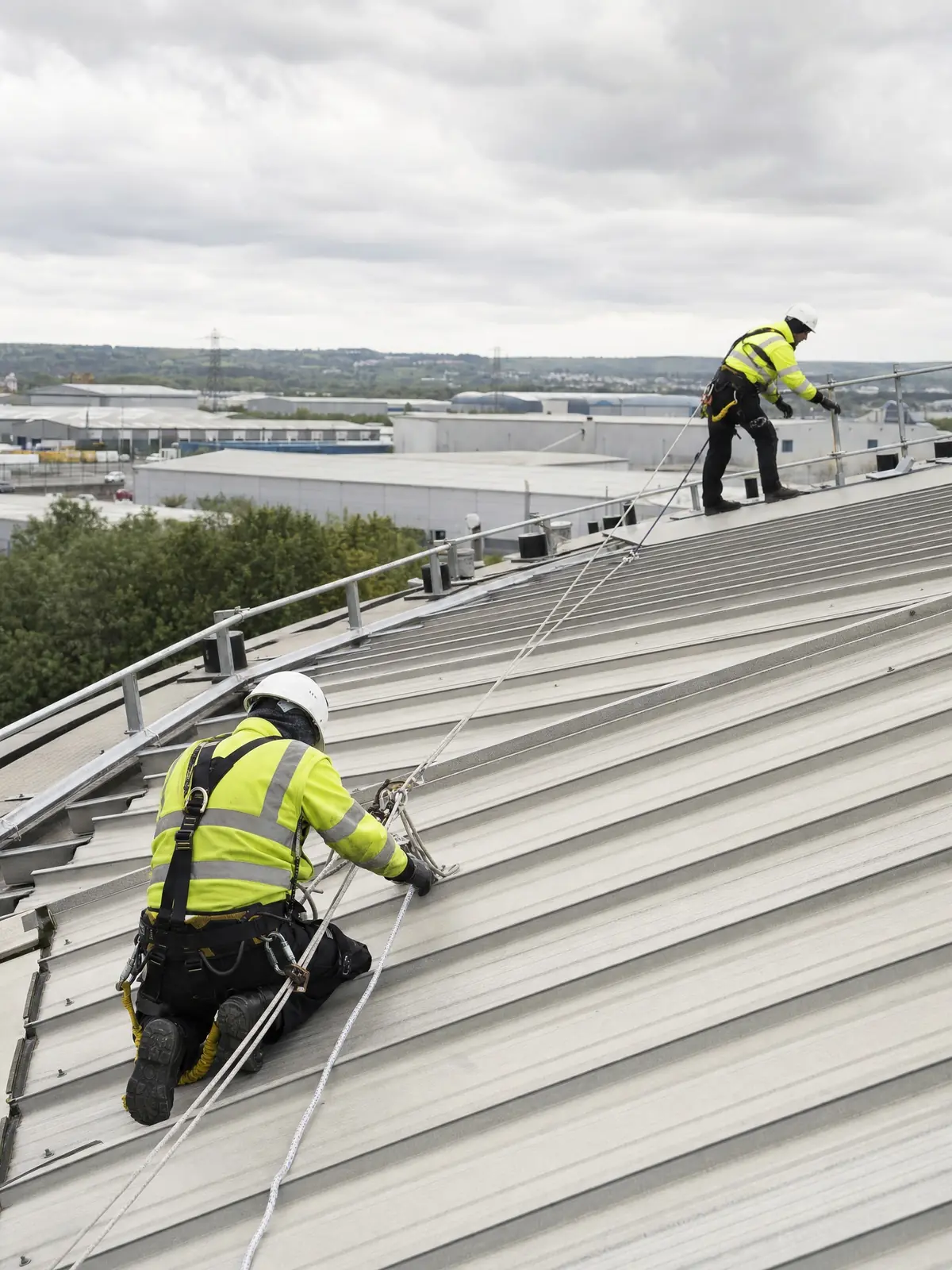 Operatives rigging safe roof access at a large commercial building